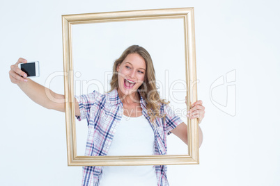 Pretty hipster taking selfie with smartphone