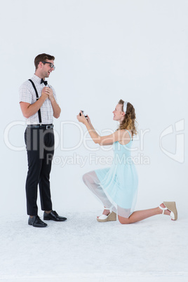 Hipster woman doing a marriage proposal to her boyfriend