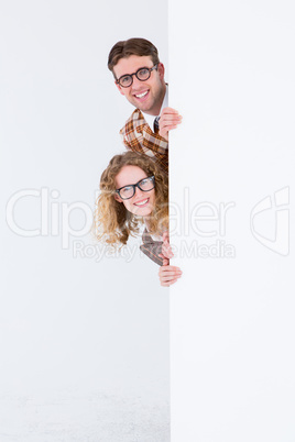 Geeky hipster holding poster and smiling at camera