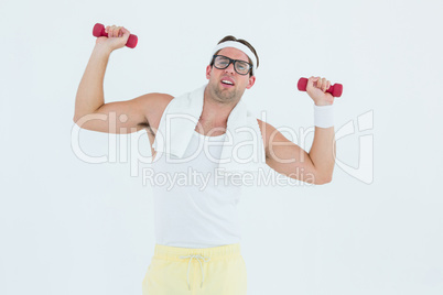 Geeky hipster lifting dumbbells in sportswear