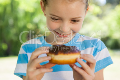 Cute little girl eating doughnut