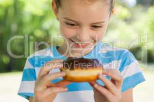 Cute little girl eating doughnut