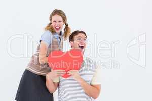 Excited geeky hipster couple with heart card