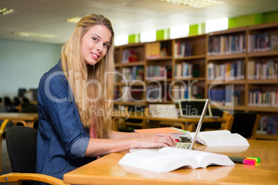 Student studying in the library with laptop