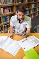 Student studying in the library with tablet