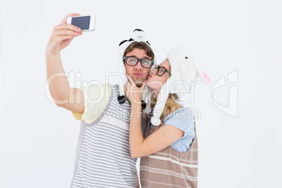 Geeky hipster couple taking selfie with smartphone