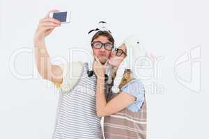 Geeky hipster couple taking selfie with smartphone