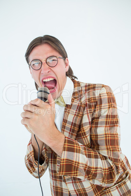 Happy geeky hipster singing with microphone