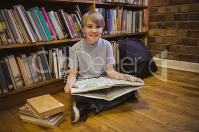 Little boy reading on library floor