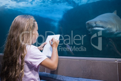 Little girl looking at fish tank