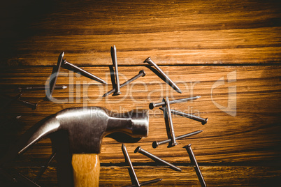 Hammer and nails laid out on table