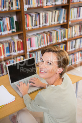 Focus teacher using laptop at library