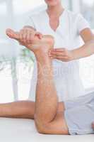 Physiotherapist doing leg massage to her patient