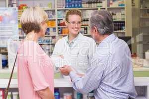 Pharmacist giving prescription to costumer