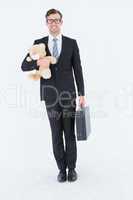 Geeky hipster businessman holding briefcase and teddy