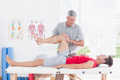 Physiotherapist doing leg massage to his patient