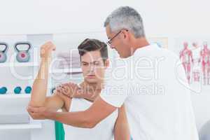 Doctor stretching a young man arm