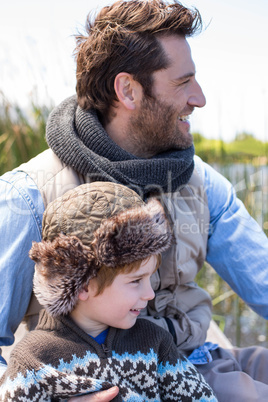 Happy casual father and son at a lake