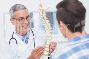 Doctor showing anatomical spine to his patient