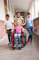 Cute disabled pupil smiling at camera with her friends