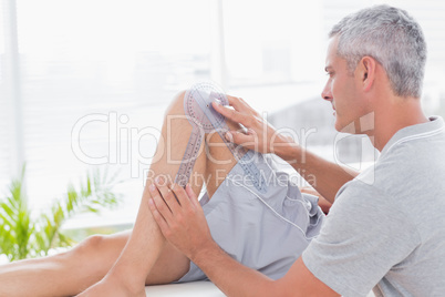 Doctor examining man leg