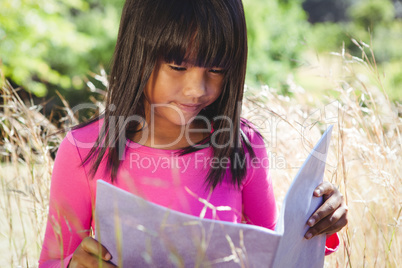 Cute little girl reading in park