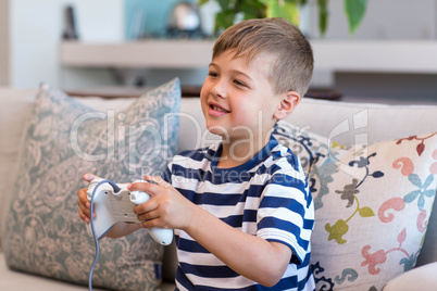 Little boy playing video games on the couch