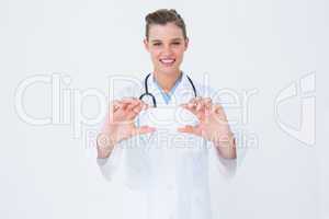 Happy doctor holding card