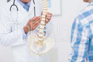 Doctor showing anatomical spine to his patient