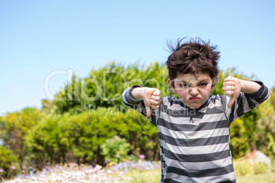 Cute boy looking at camera thumbs down