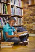 Little boy reading on library floor