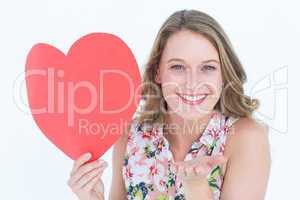 Woman holding heart card and blowing kiss