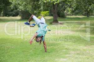 Hipster doing back flip in the park