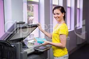 Student photocopying her book in the library