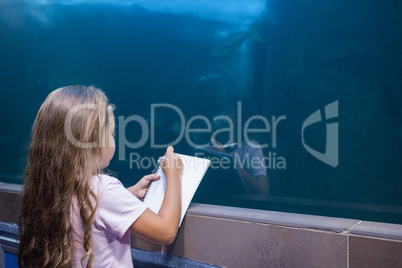 Little girl looking at fish tank