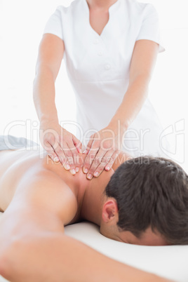 Physiotherapist doing shoulder massage to her patient