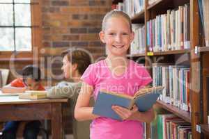 Cute pupil reading in library