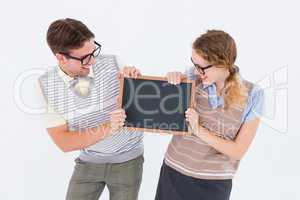 Geeky hipster couple holding little blackboard