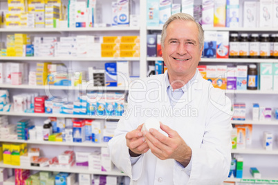 Smiling pharmacist holding a box of pills