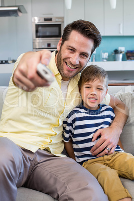 Father and son watching tv together on the couch