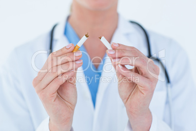 Doctor holding broken cigarette