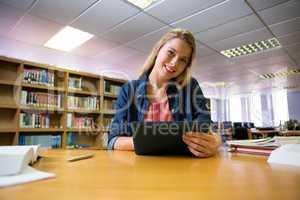 Student studying in the library with tablet