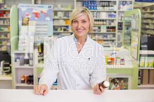 Smiling pharmacist holding medicine jar