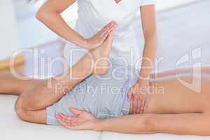 Physiotherapist doing leg massage to her patient