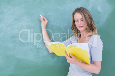 Smiling teacher writing on blackboard