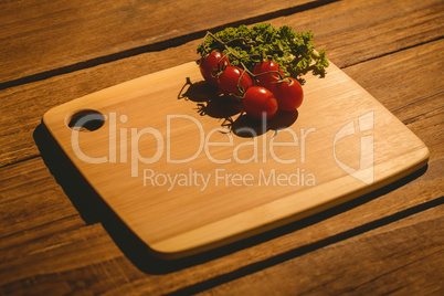 Cherry tomatoes and parsley on chopping board