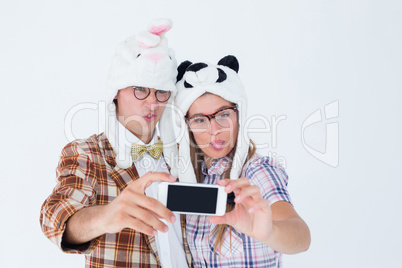 Geeky hipster couple taking selfie with smart phone