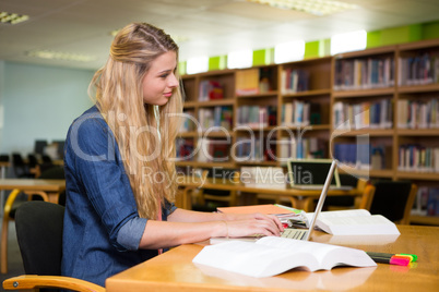 Student studying in the library with laptop