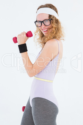 Geeky hipster posing in sportswear with dumbbell