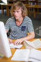 Student studying in the library with computer